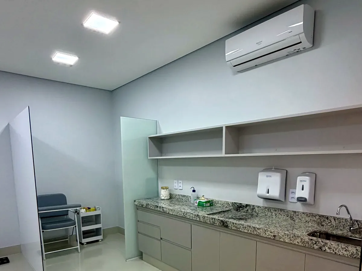 Sala de procedimentos do Laboratório Exato com bancada, pia e área de coleta ao fundo